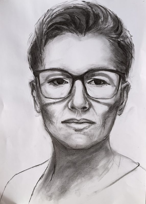 Charcoal self-portrait of a young woman with dark-rimmed glasses, head and shoulders